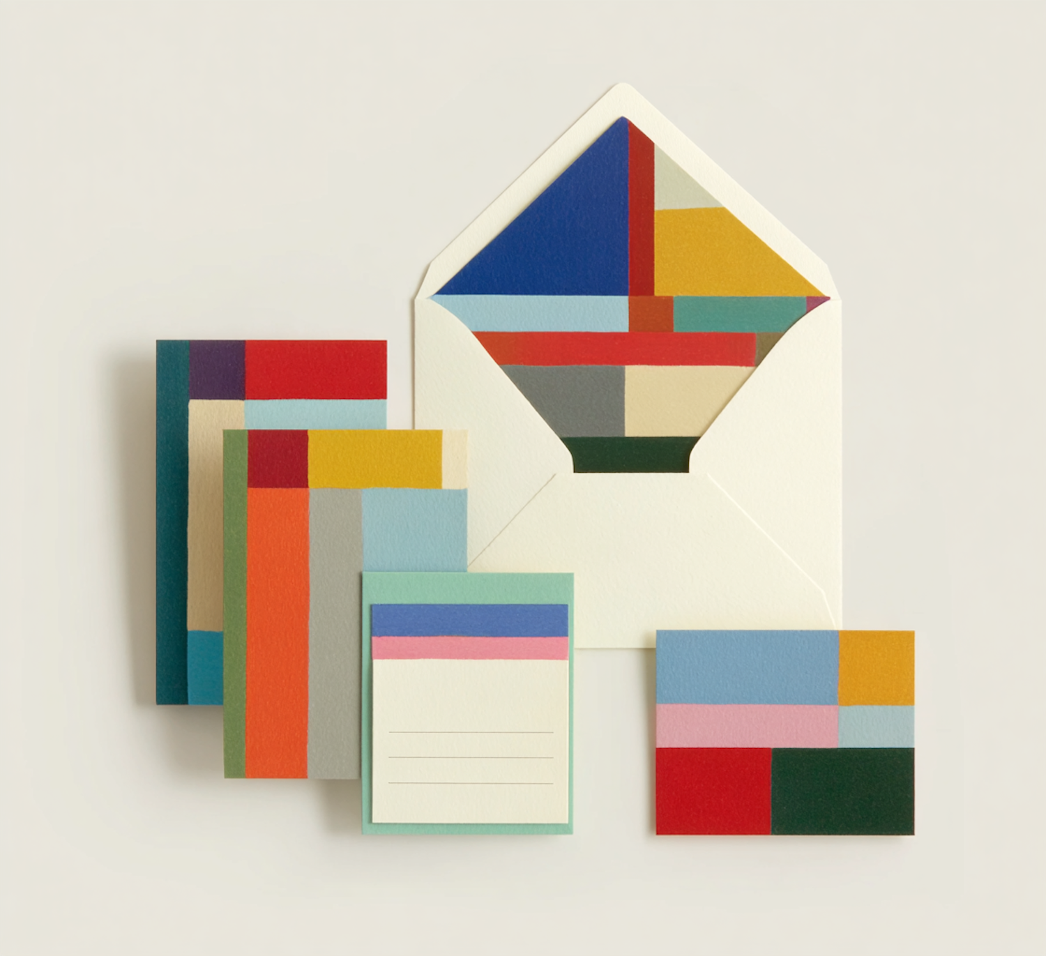 Stationery set of geometric printed cards and an envelope on a neutral surface